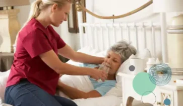 carer helping patient in bed